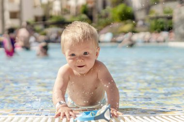 Sarışın bebek havuzu yüzme gözlüğü ile oynarken