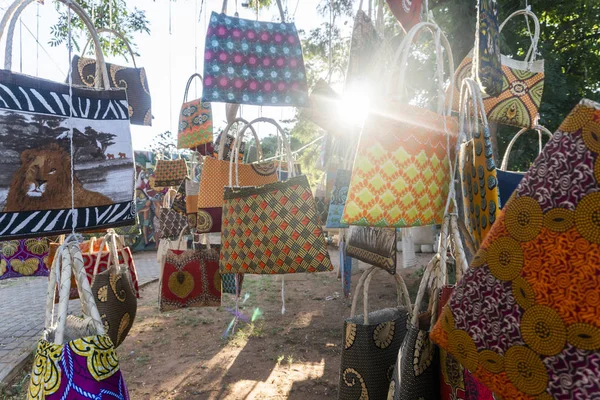 Mercado africano tradicional vendiendo bolsas de colores colgadas en el árbol — Foto de Stock