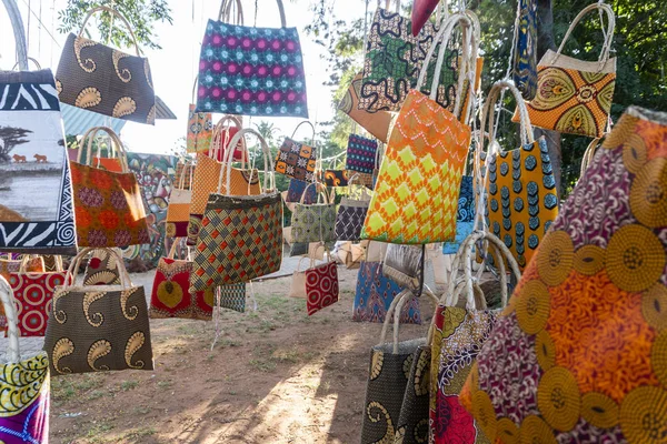 Mercado africano tradicional vendiendo bolsas de colores colgadas en el árbol — Foto de Stock