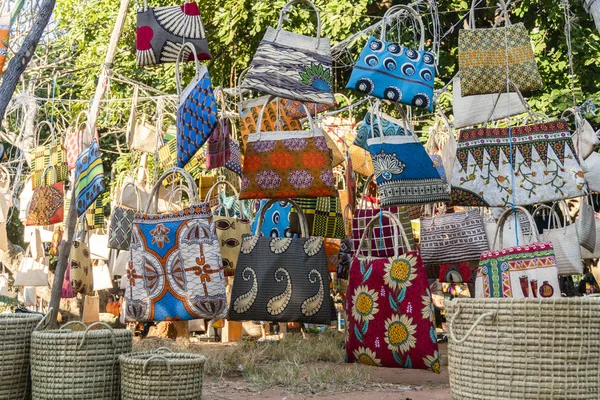 Mercado africano tradicional vendendo sacos coloridos pendurados na árvore — Fotografia de Stock