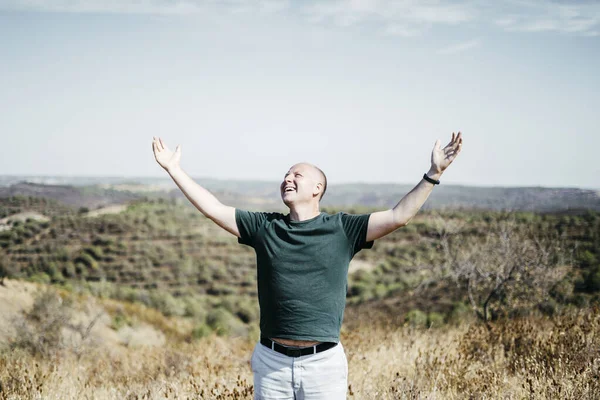 Hombre en el desierto disfrutando del sol extendiendo sus brazos hacia arriba — Foto de Stock