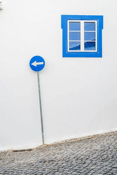 Blue window and blue road sign in mediterranean village — Stock Photo, Image
