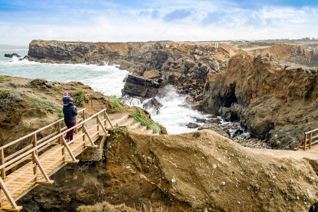 Father and little son admiring beautiful Papoa islet in Peniche, Leiria district, Portugal