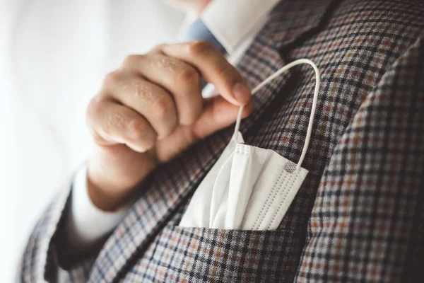 Elegant man with protective mask as handkerchief in chest pocket of his suit