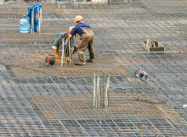 The employee works on the construction site. Performed   work electric tools for cutting reinforcement.