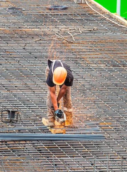 The employee works on the construction site. Performed work electric tools for cutting reinforcement.