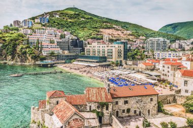  Budva eski kasaba parçası: antik duvarlar ve kırmızı kiremitli çatı ve modern Beach, Karadağ, Europe bir görünüm. Budva Adriyatik Riviera en iyi ve en popüler tatil biridir.