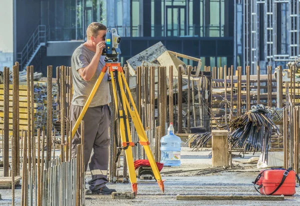Kiev, Ukrayna - 10 Eylül 2019: Bir şantiyede teodolit ile çalışan eksper tetkik mühendisi.