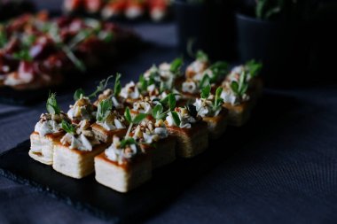 Canapes with prosciutto and green pea leaves.