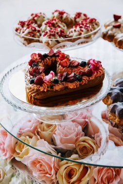 Çilek ile süslenmiş kalp şeklinde Kek, bir ziyafet masasında servis.