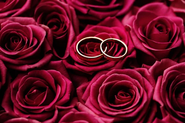 赤いバラの花束に置かれた2つの結婚指輪 クローズアップ画像 — ストック写真