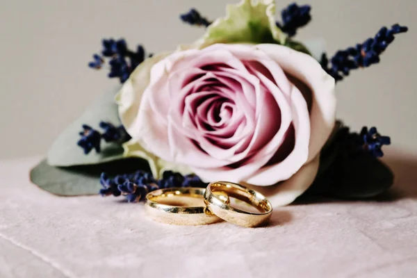 2つの金色の結婚指輪と花束 — ストック写真