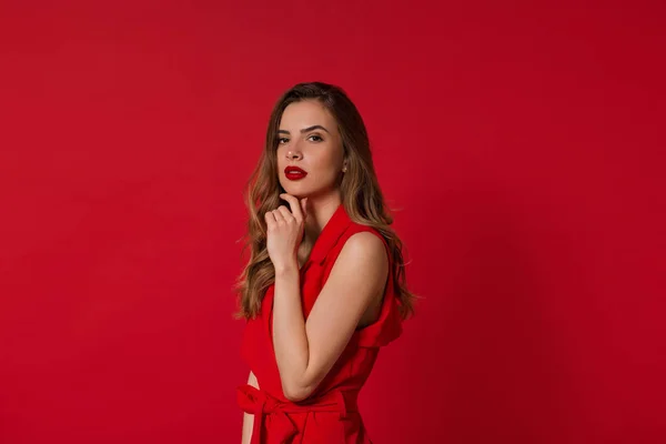 Impresionante expresión de cara de modelo femenino sobre fondo rojo. Retrato de cerca de la chica europea con estilo Fotos de stock libres de derechos