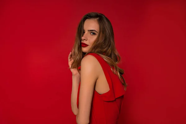 Close up dentro do estúdio retrato de mulher elegante adorável com lábios vermelhos e vestindo vestido vermelho sobre fundo isolado — Fotografia de Stock