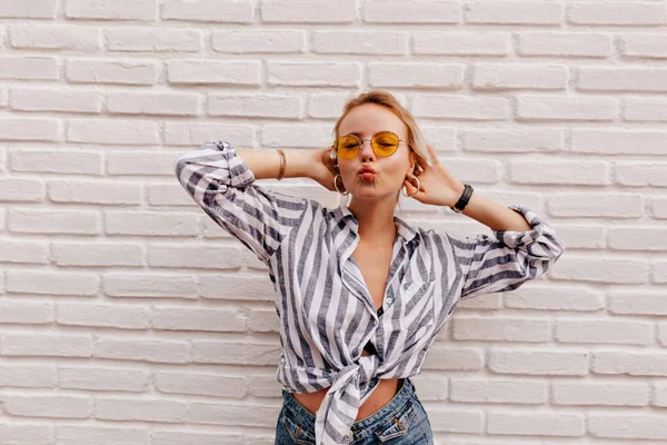 Attractive stylish caucasian woman with blond hair wearing stripped shirt sending a kiss  over isolated background — Stock Photo, Image