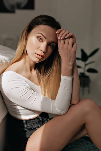 Atraktivní mladý stylový model s bílou kůží a blonďatými vlasy, který se dívá na fotoaparát na slunci. — Stock fotografie