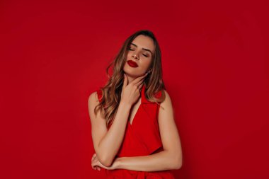 Altın saçlı zarif kendine güvenen bayan photoshoot zevk. Kırmızı elbise giyen romantik genç kadının stüdyo portresi 