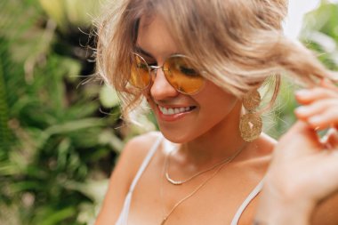 Şık modern sarı gözlük giyen sarışın kıvırcık saçlı sevimli mutlu kız portresi dışında yakın 