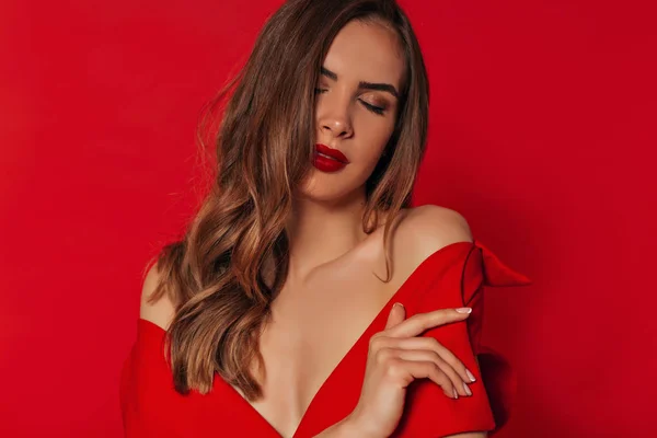 Ternura romántica mujer con estilo brillante con cabello ondulado de oro y maquillaje brillante con vestido rojo con hombros desnudos —  Fotos de Stock