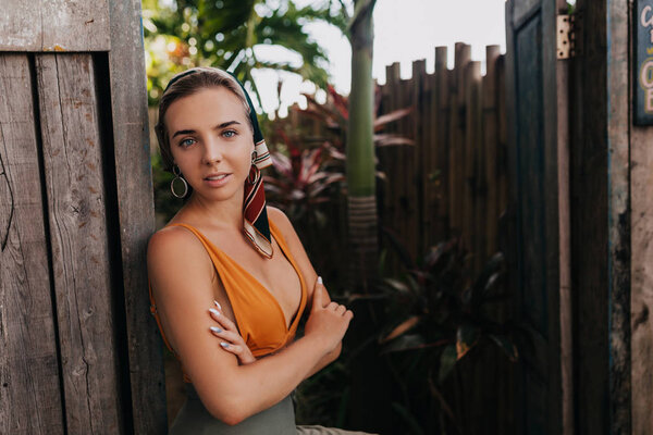 Крупным планом портрет элегантной модной девушки в летнем наряде смотрит в камеру с мягкой улыбкой
