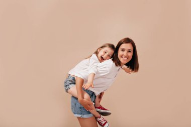Güzel kızı ile genç kadının aile portresi, izole arka plan üzerinde sırtına sürme