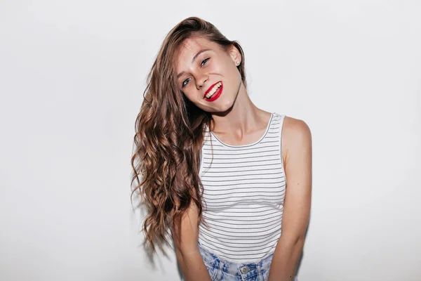 CLose up portrait happy woman with long wavy hair with red lips looking at camera with smile over isolated background