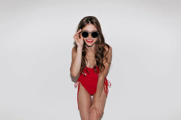 Efektivně stylová moderní krásná dívka s červeným plavním obletem a černými slunečními brýlemi na izolované pozadí — Stock fotografie