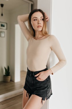 Modern dairede photoshoot sırasında poz bej vücut ve şort giyen Inanılmaz şık genç kadın 