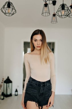 İlgilenen kafkas kız modern dairede ayakta . Evde ürpertici rahat sarışın kadın. 