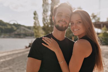 Genç çekici çift siyah gömlek yürüyüş giyen ve güneş ışığı dışında eğlenmek