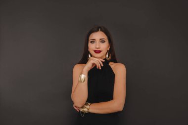 Güzel, sevimli, sevimli, dikkatsiz, şanslı kadın. Parlak akşamlı. Siyah arka planda izole edilmiş makyaj yapıyor.