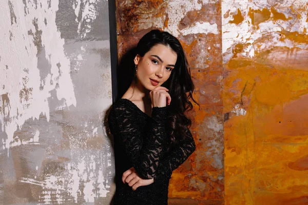 Primer plano retrato de mujer elegante y elegante con pelo oscuro con vestido negro de noche sobre fondo gris —  Fotos de Stock