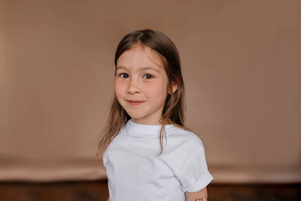 Indah bahagia gadis kecil mengenakan t-shirt putih tersenyum di kamera atas latar belakang terisolasi — Stok Foto