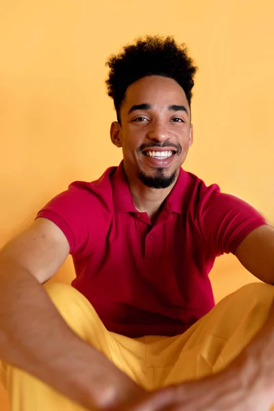 Sonriente millennial feliz sonriente chico negro posando para la foto, mirando a la cámara vistiendo en ropa de verano, aislado en el fondo del estudio amarillo . —  Fotos de Stock