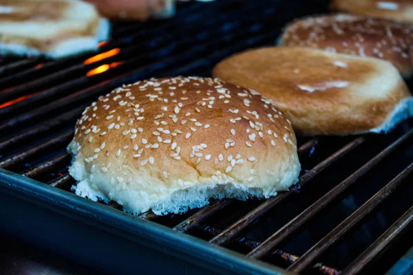 ごまの種をグリルしたハンバーガーパン 屋外暖炉でバーベキューバーベキューグリルでローストバーガーパンを準備 — ストック写真