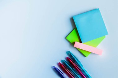 Post-it notlar ve beyaz arka plan üzerinde renkli kalemler. Beyaz arka planda not almak için not çıkartmaları gönderme.