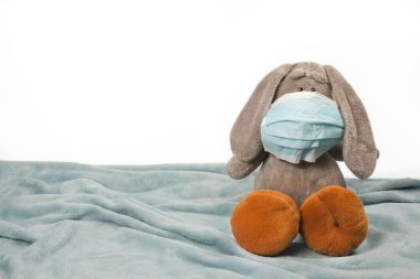 Maskeli hasta, üzgün, peluş bir oyuncak. Grip salgını virüsü bakterisi. Pelüş eşek oyuncağı koruyucu maske tak, Coronavirüs konseptine karşı koru.