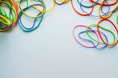 Beyaza izole edilmiş renkli lastik bantların üst görüntüsü. Gökkuşağı lastik bantlar beyaz üzerine