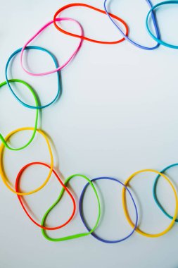 Beyaza izole edilmiş renkli lastik bantların üst görüntüsü. Gökkuşağı lastik bantlar beyaz üzerine