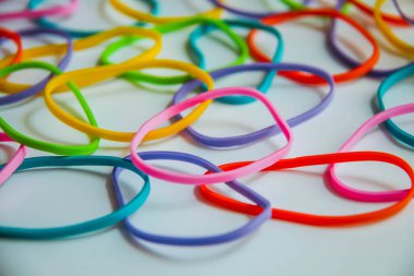 Renkli lastik bantların beyaza yan görünüşü. Beyaz üzerine gökkuşağı elastik lastikler. Seçici odak.