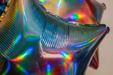 Helyum dolu bir sürü folyo mavisi balon. Beyaz üzerinde holografik helyum yıldız balonları.