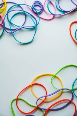 Beyaza izole edilmiş renkli lastik bantların üst görüntüsü. Gökkuşağı lastik bantlar beyaz üzerine