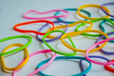 Beyaza izole edilmiş renkli lastik bantların üst görüntüsü. Gökkuşağı lastik bantlar beyaz üzerine