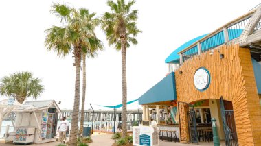 Destin FL, United States - December 27, 2024: Waterfront restaurant Azul located at HarborWalk Village features palm trees and an inviting outdoor seating area