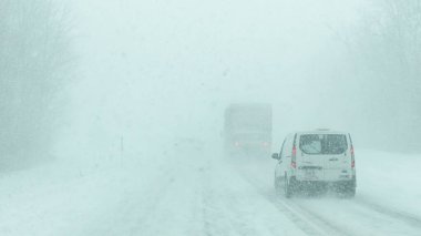 Syracuse NY, ABD - 3 Ocak 2025: Şiddetli kar yağışı ve kış hava koşulları altında araçlar karlı bir yolda ilerliyor