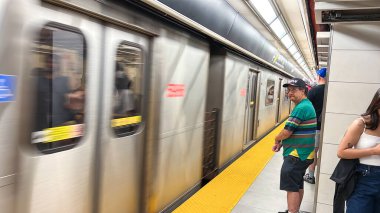 Toronto, Canada - June 29, 2025: Subway TTC train approaches the station as passengers stand on the platform, highlighting the hustle of urban transportation and daily commuting experiences