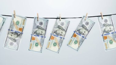 Para aklama, mali suç ve yasadışı gelir kavramı. Çamaşır ipine asılmış birkaç yüz dolarlık banknotlar. Finansal tema. Ekonomi ve iş kavramı. Stüdyo çekimi.