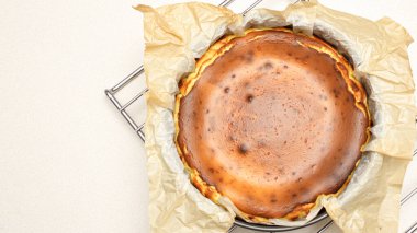 Beyaz arka planda çatlakları olan ev yapımı lezzetli fırınlanmış cheesecake 'in göz kamaştırıcı üst görüntüsü.