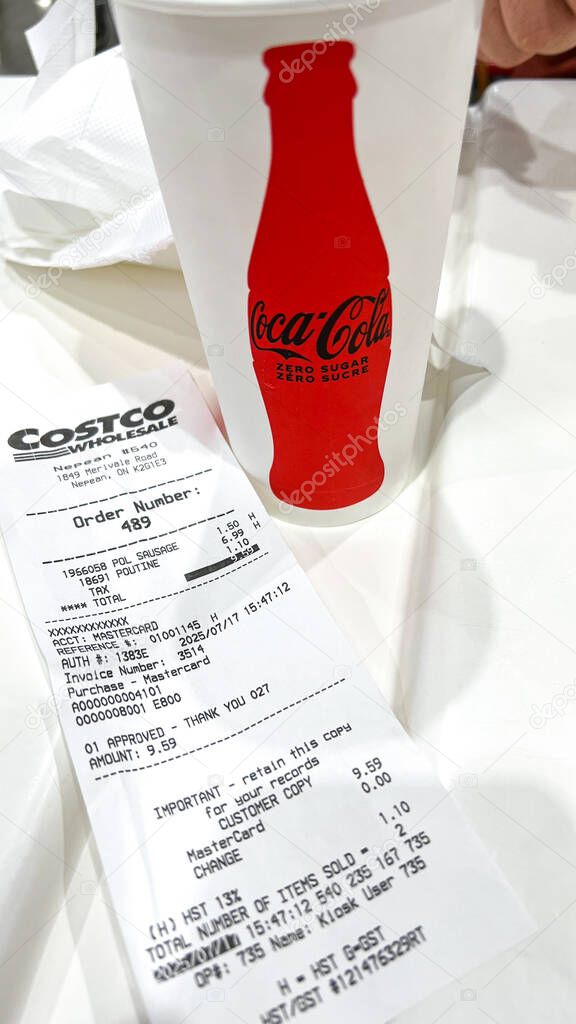 Ottawa, ON Canada - July 19, 2025: Coca-Cola drink served in a Costco cup with a receipt on a table highlighting a lively food court atmosphere. transition from Pepsi to Coca-Cola beverage