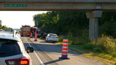 Mont-Tremblant QC Canada - 22.09.2024: The scene depicts a long line of cars stuck bumper-to-bumper under the bridge during peak rush hour. The traffic is heavy, and many vehicles are attempting to merge, creating a chaotic atmosphere.